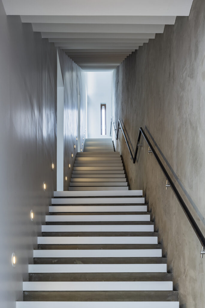 A photograph looking up a stairwell of four flights of steps from the bottom.