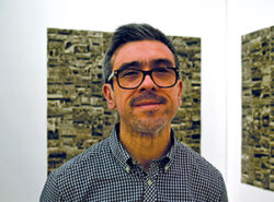 Headshot of Raúl Cárdenas Osuna, dressed in a plaid shirt, smiling at the camera.