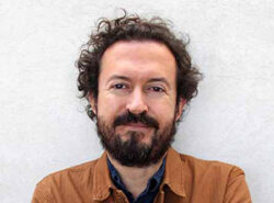 Headshot of Gabriel Diaz Montemayor, dressed in brown, smiling at the camera.