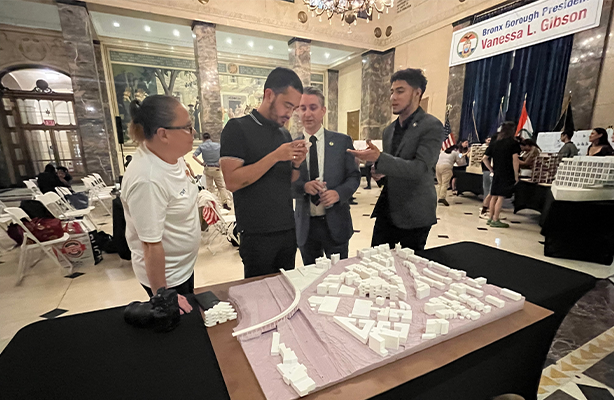 Four people standing behind an architectural model