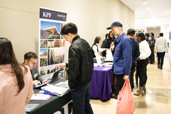 Two students standing in front of an employer's booth at the Career Fair.