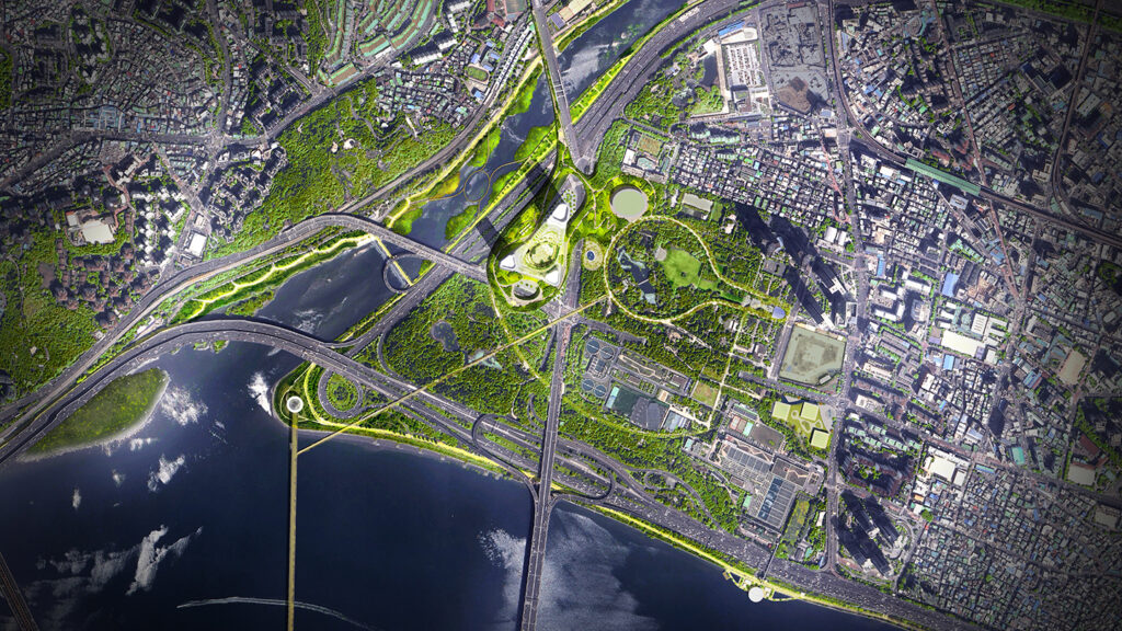 An aerial, top-down view of a modern urban landscape where a dense city grid meets a lush green park and a wide river. A complex network of highways and bridges meanders through the greenery and across the dark blue water. The central focus is a large, contemporary building complex with organic, curved shapes and integrated rooftop gardens, surrounded by a circular walking path that winds through the surrounding forest and open parkland.