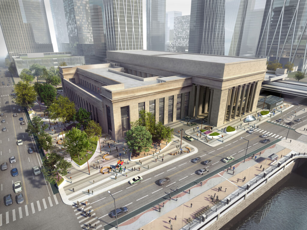 An architectural rendering of the 30th Street Station area in Philadelphia, Pennsylvania. The historic, neoclassical station building, featuring massive stone columns and a grand entrance, is the central focus. The surrounding streetscape has been reimagined with wide, light-colored stone pedestrian plazas, modern curved wooden benches, and newly planted trees. A multi-lane road with cars and taxis runs alongside the station, bordered by a scenic riverfront walkway where people are walking and cycling. In the background, sleek, modern glass skyscrapers rise into a hazy sky, contrasting with the classical architecture of the station.
